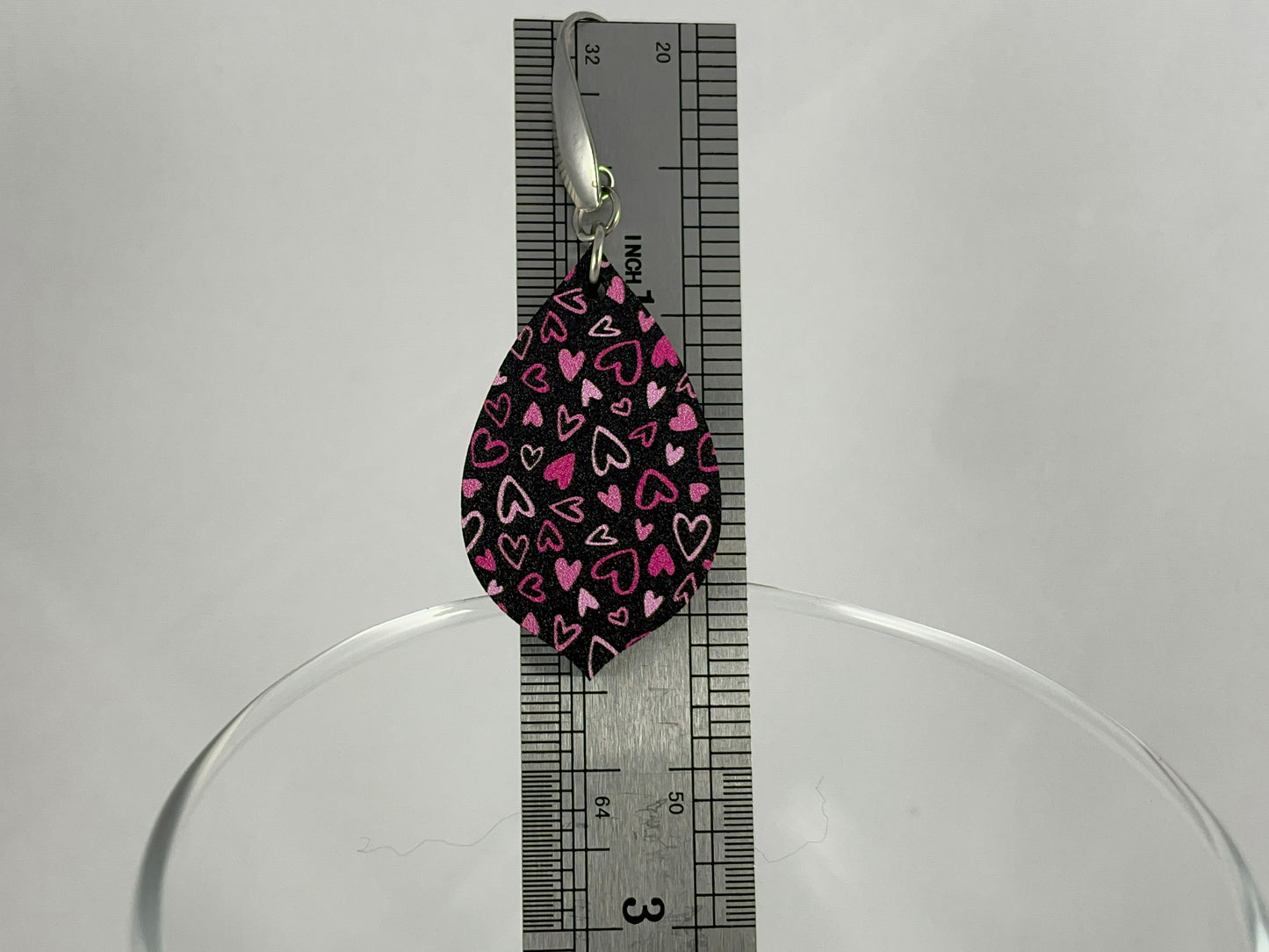 Size reference showing 2.25" drop length for Pink on Black Micro-Print Hearts teardrop shaped acrylic earrings on stainless steel ear wires
