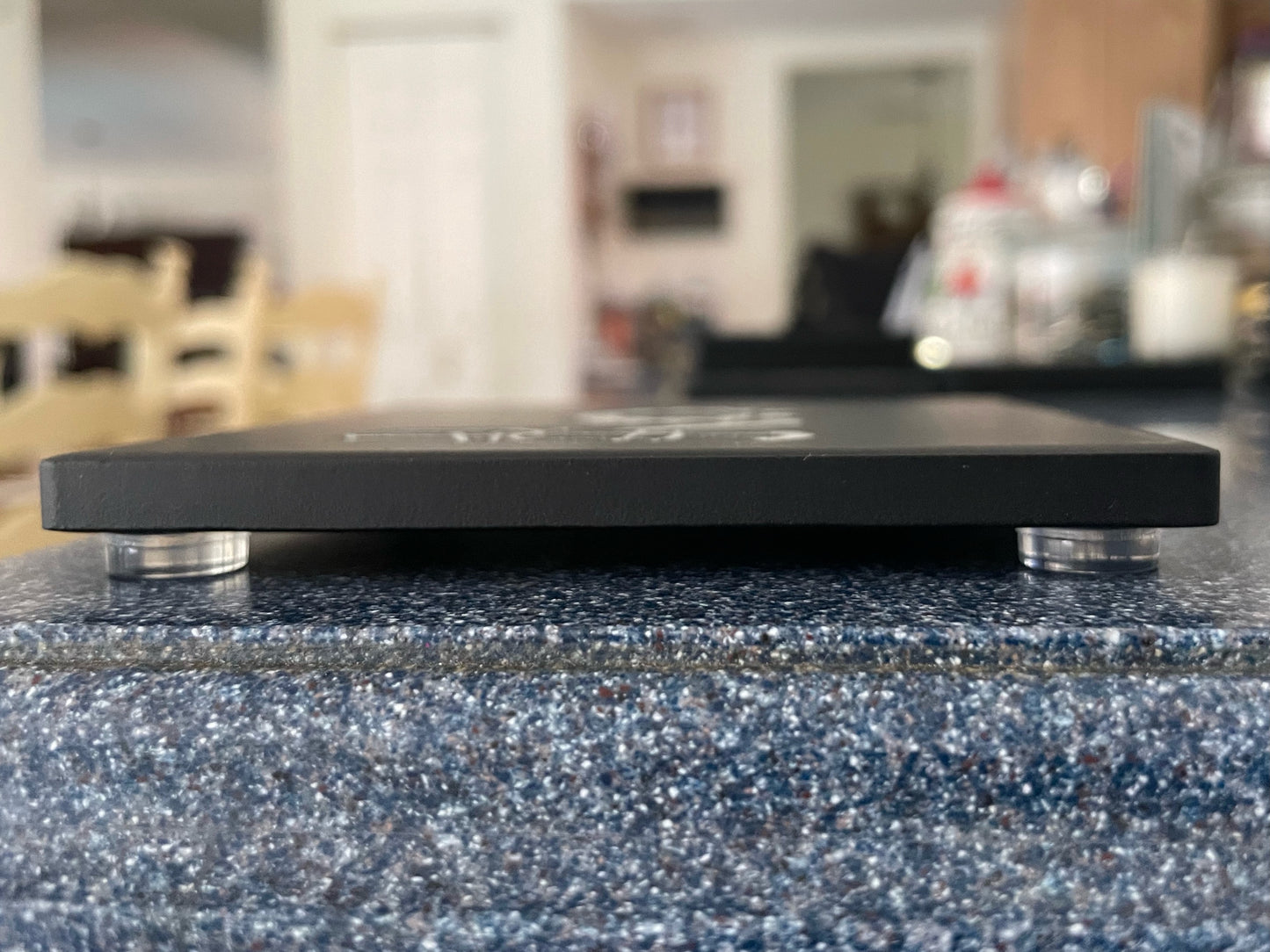 Black ceramic coaster side view showing clear silicone bumpers