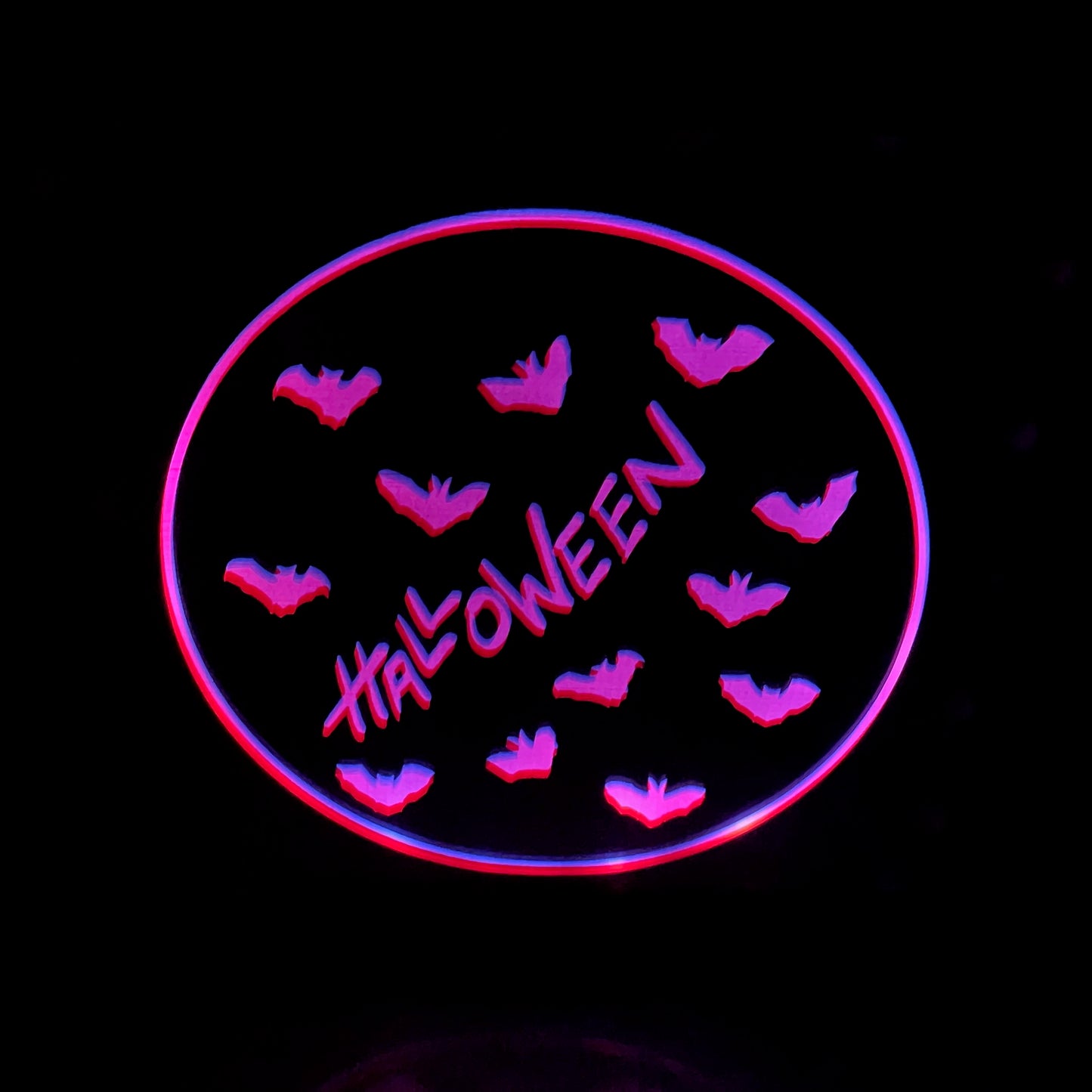 Halloween bats engraved on mirror illuminated by pink LED lights