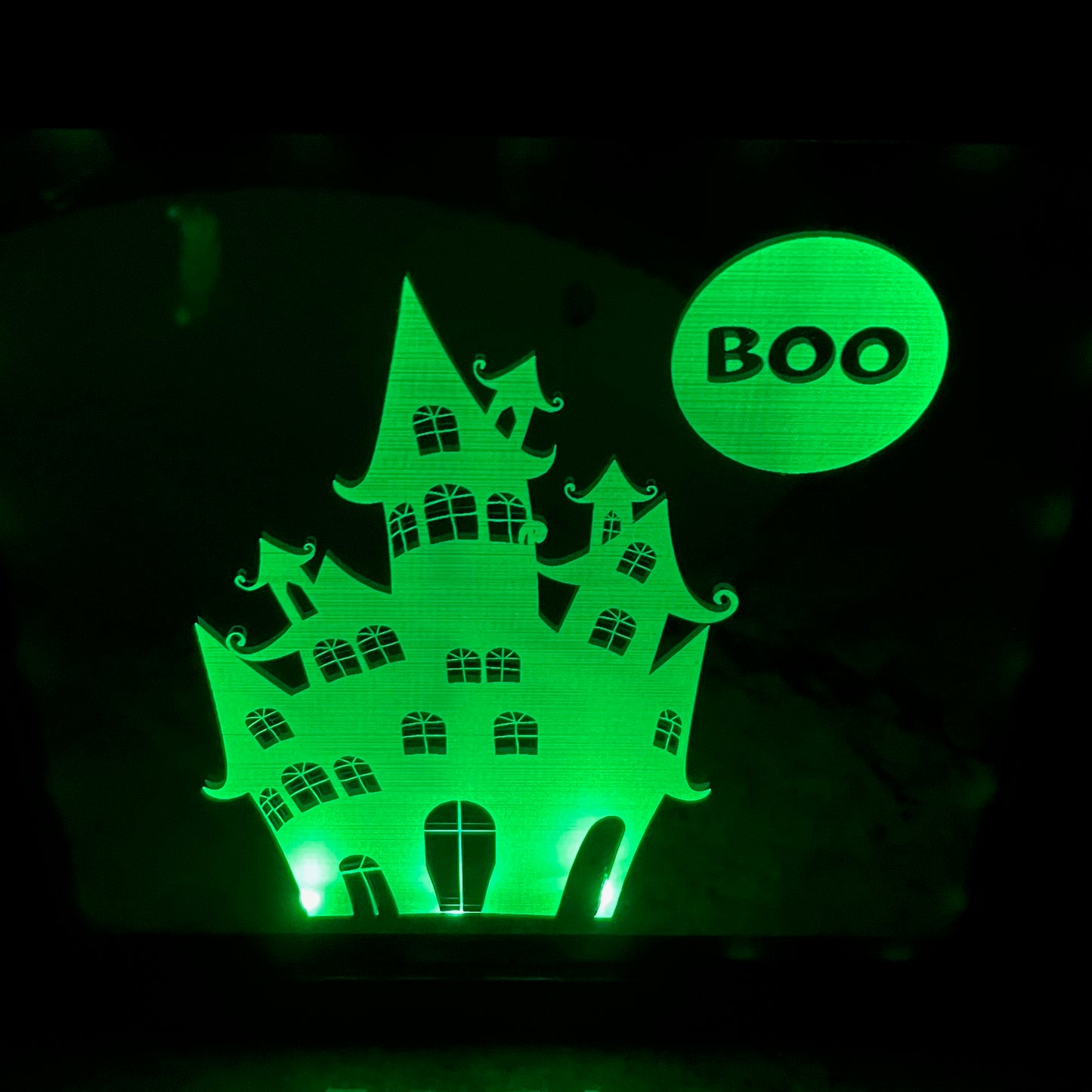 Haunted house engraved on mirror in shadow box frame illuminated green