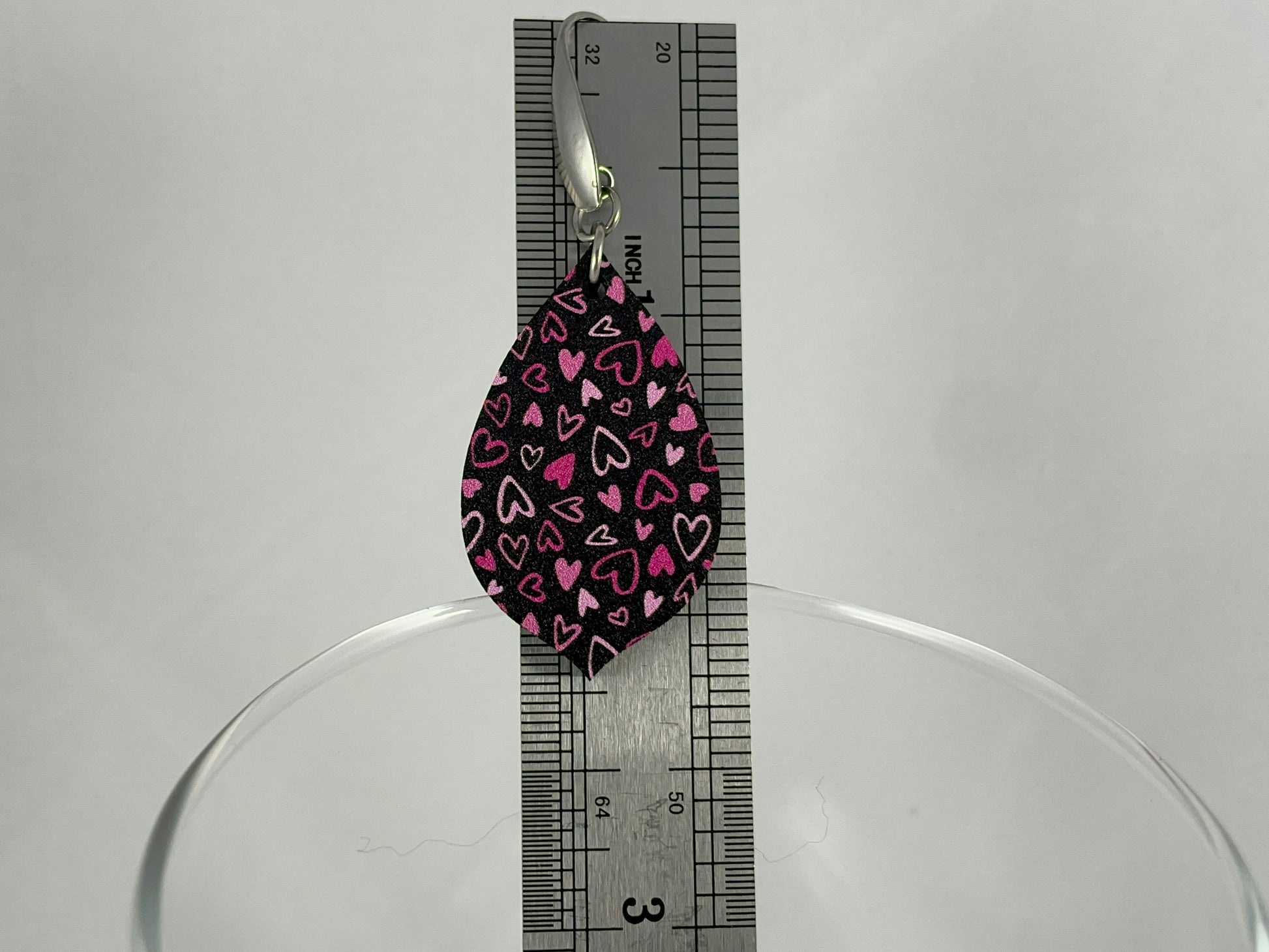 Size reference showing 2.25" drop length for Pink on Black Micro-Print Hearts teardrop shaped acrylic earrings on stainless steel ear wires 