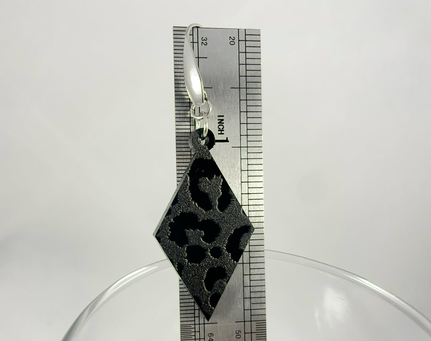 Size reference showing drop length of 2.5" for Diamond-shaped leopard print black on black ac relic earrings on stainless steel ear wires with teardrop accent