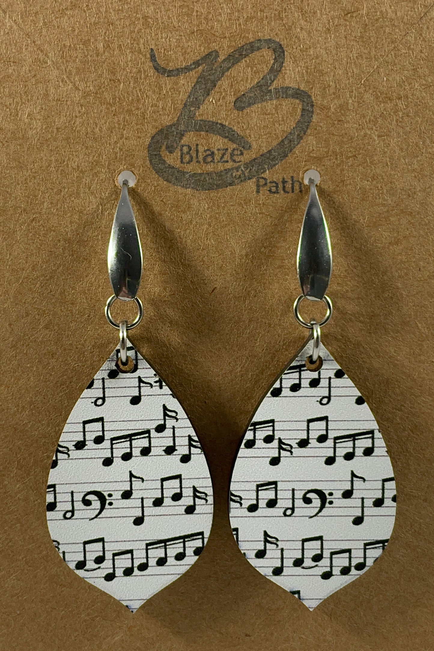 Acrylic earrings with black music notes on white background and stainless steel ear wires with teardrop accent