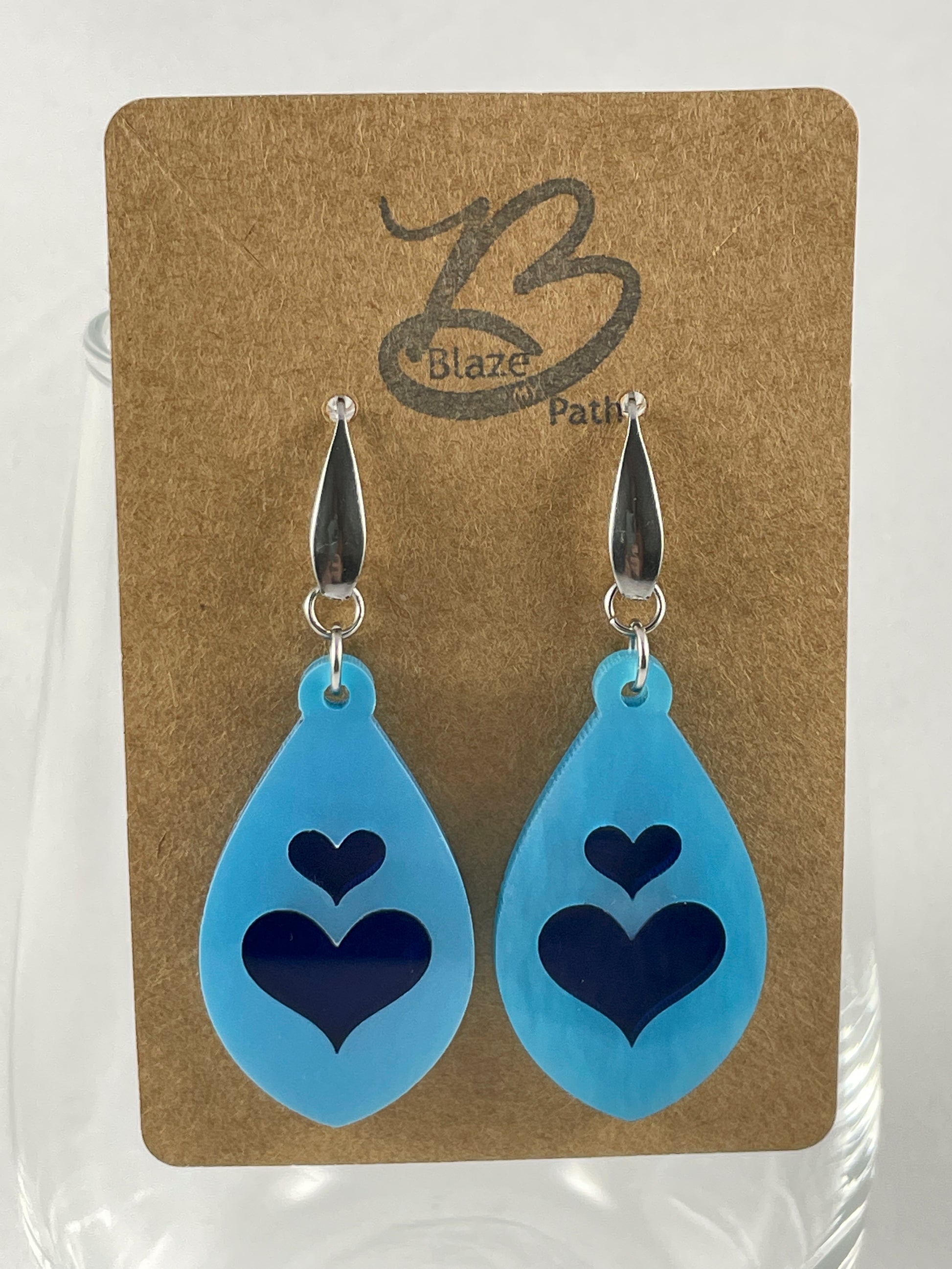 Light blue acrylic teardrop earrings with lapis blue inlay hearts on stainless steel ear wires with teardrop accent